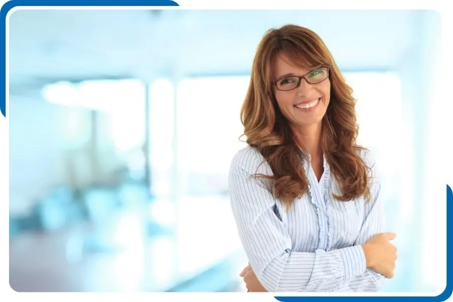 Confident professional woman in glasses, standing in a bright office, representing customer support in hair drug and alcohol testing services