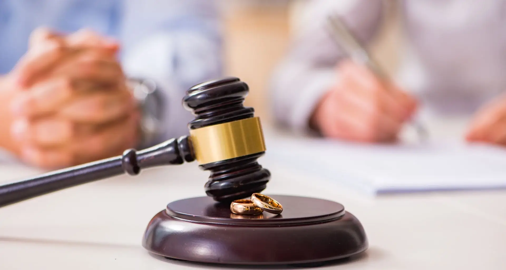 Gavel and wedding rings on a table during divorce proceedings, emphasizing the role of hair drug and alcohol testing in legal decisions.