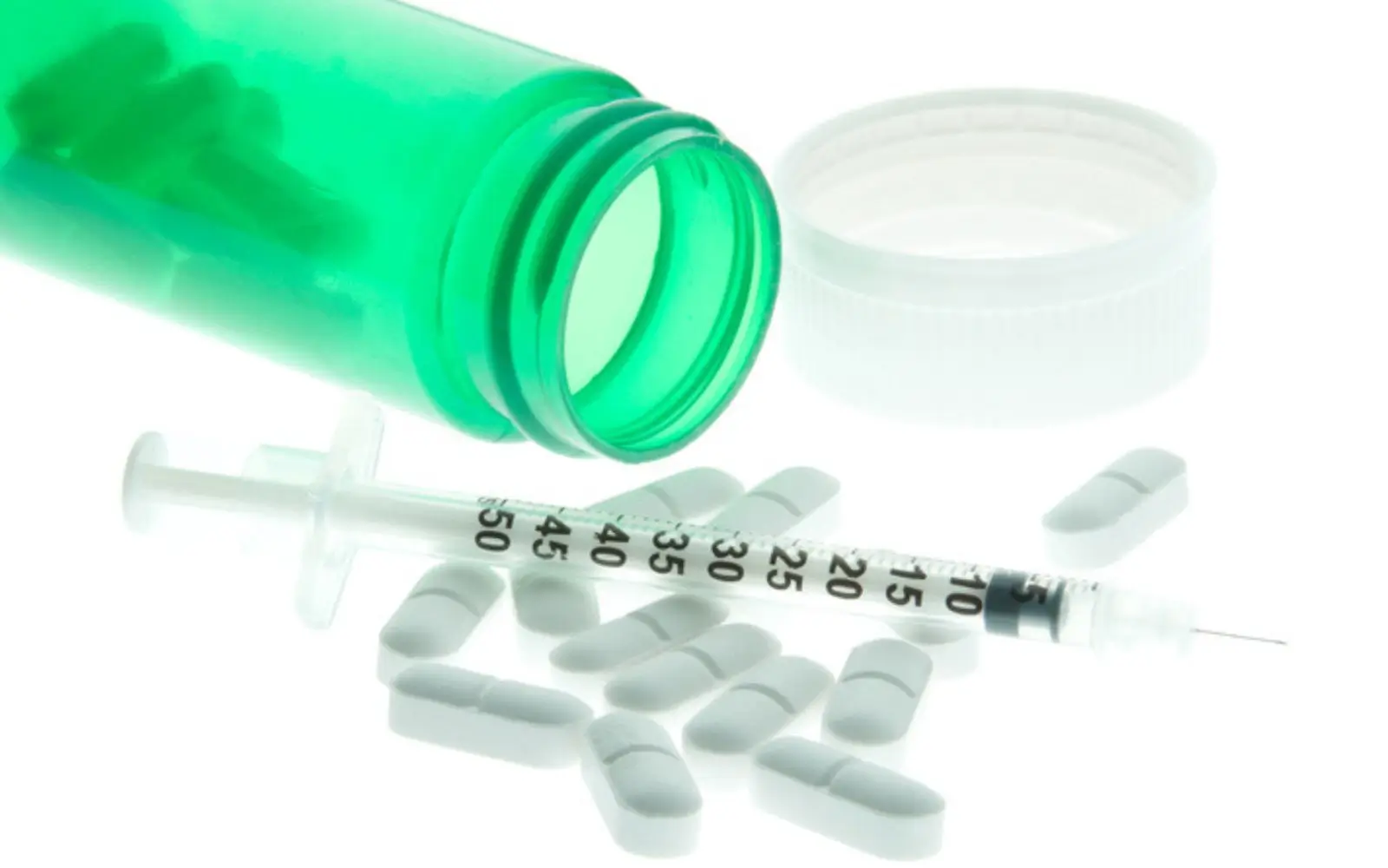 Medical testing supplies including a syringe, white pills, and a green glass bottle, symbolizing the precision and care in hair drug testing processes.