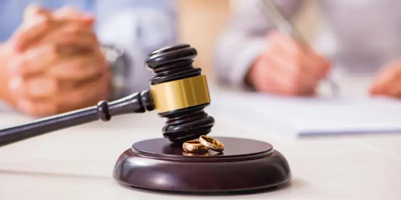 Gavel and wedding rings on a table during divorce proceedings, emphasizing the role of hair drug and alcohol testing in legal decisions.