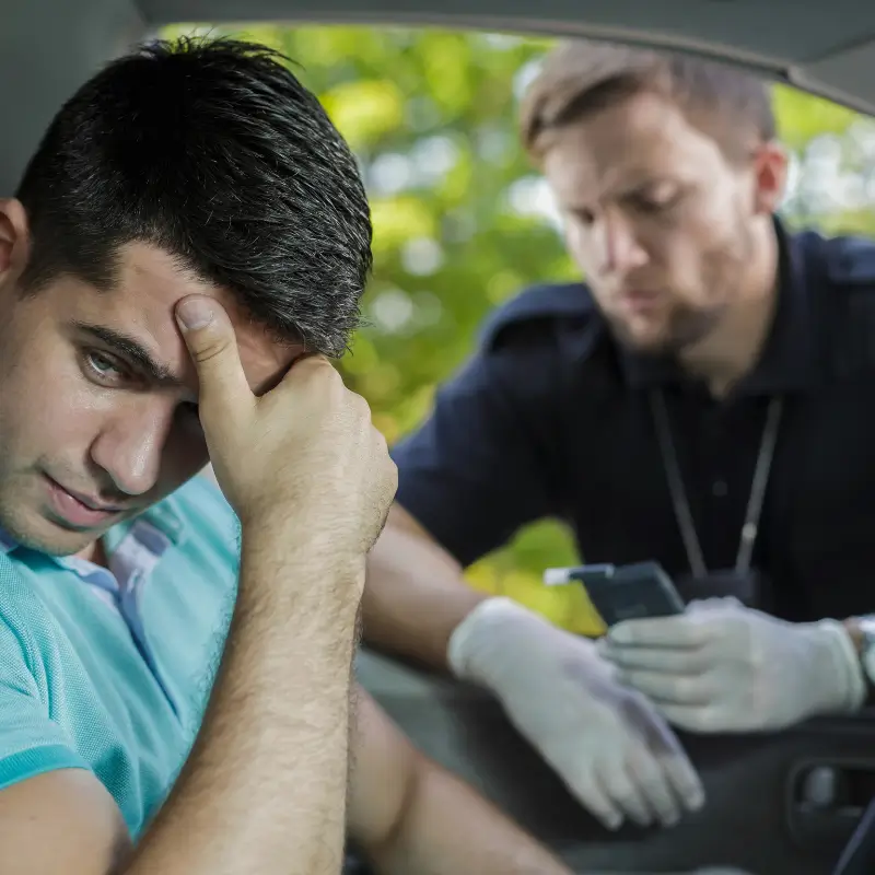 Driver concerned during roadside saliva drug test with police officer checking results