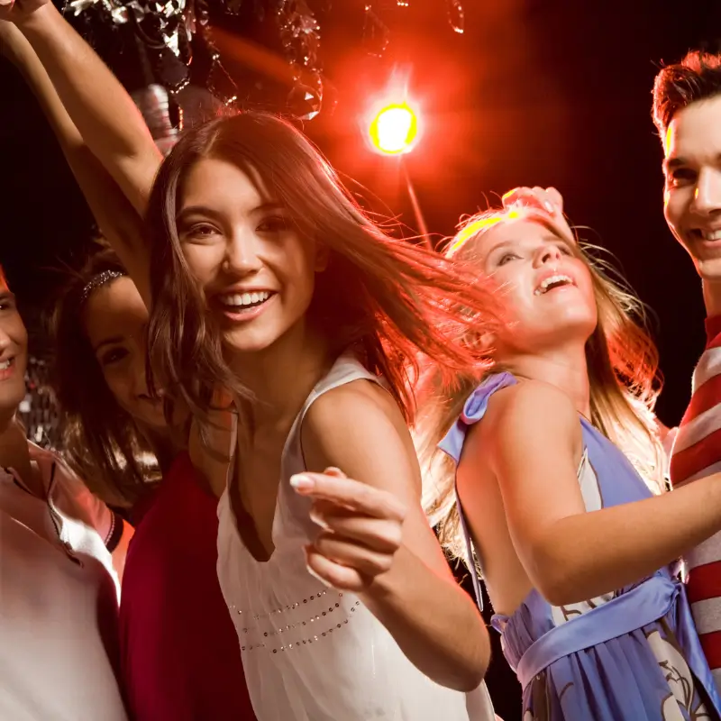 Group of friends dancing at a party enjoying music and fun nightlife using party drugs and/or alcohol